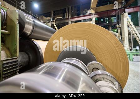 Produktionsprozess in einer Papierfabrik mit Schwerpunkt auf der Papiermaschine und den Rollen Stockfoto