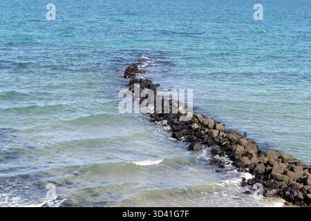 Ruhige Meeresszene mit einem felsigen Wellenbrecher in Elliott Heads nahe Bundaberg in Queensland, Australien Stockfoto