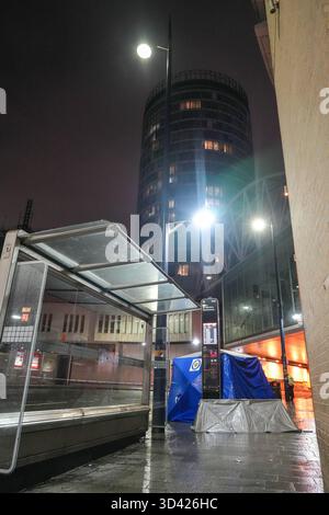 Smallbrook Queensway, Birmingham, 8. November 2025 - die Polizei von West Midlands schloss einen Straßenabschnitt direkt vor dem Bullring-Einkaufszentrum und der New Street Station, nachdem am Freitagabend eine Frau in den Hals gestochen wurde, wurde ein Mann mit 20 Jahren verhaftet. Mehrere forensische Zelte wurden in der Nähe einer Bushaltestelle errichtet. Zwei kleine silberne Zelte und ein großes blaues Beweissenzelt wurden auf dem Bürgersteig um ein kleines Kabel gelegt, das die Straße absperrte. Zwei Polizisten blieben die ganze Nacht am Tatort. West Midlands Police Statement: Ein Mann ist in Haft nach einem Messerstecher in Birmingh Stockfoto