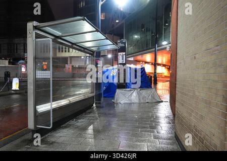 Smallbrook Queensway, Birmingham, 8. November 2025 - die Polizei von West Midlands schloss einen Straßenabschnitt direkt vor dem Bullring-Einkaufszentrum und der New Street Station, nachdem am Freitagabend eine Frau in den Hals gestochen wurde, wurde ein Mann mit 20 Jahren verhaftet. Mehrere forensische Zelte wurden in der Nähe einer Bushaltestelle errichtet. Zwei kleine silberne Zelte und ein großes blaues Beweissenzelt wurden auf dem Bürgersteig um ein kleines Kabel gelegt, das die Straße absperrte. Zwei Polizisten blieben die ganze Nacht am Tatort. West Midlands Police Statement: Ein Mann ist in Haft nach einem Messerstecher in Birmingh Stockfoto