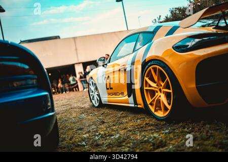 Mailand, italien 28. oktober 2025: porsche cayman gt4 clubsport in Gelb mit schwarzen Rennstreifen, elegantem Mittelmotor-Design und spurbereitem per Stockfoto