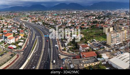 Luftpanorama von Tirana, Albanien, zeigt den nordwestlichen Abschnitt der äußeren Ringstraße, umgeben von Wohnhäusern und Bergen. Stockfoto