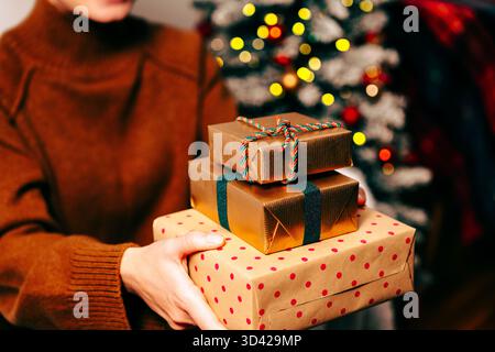 Weihnachtsgeschenke in festlichem Papier in den Händen einer Frau Stockfoto