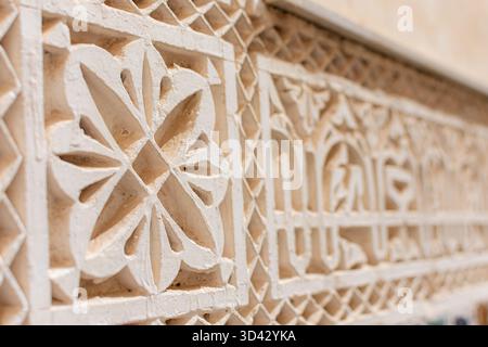 Detaillierte Nahaufnahme komplizierter, sternförmiger islamischer Stuckarbeiten im Mausoleum von Moulay Ismail in Meknes, Marokko, die Handwerkskunst hervorheben Stockfoto