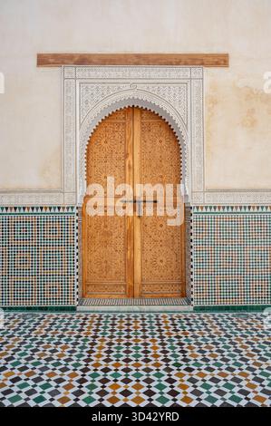 Der Eingang ist sehr dekoriert und von aufwändigen zelligen Fliesen und einem gemusterten Boden im Mausoleum von Moulay Ismail in Meknes, Marokko, eingerahmt. Stockfoto