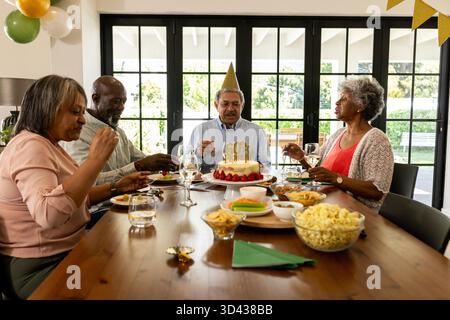 Anlässlich des Geburtstags genießen verschiedene Gruppen Mahlzeiten und Getränke am Esstisch. Feier, Party, Freundschaft, Zusammenkommen, Glück, multikulturelles || Modell veröffentlicht Stockfoto