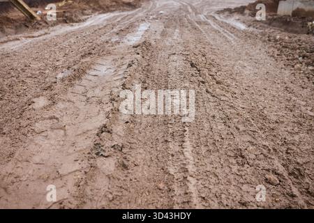 Ländliches, schlammiges Gelände, unebener ländlicher Pfad mit Pfützen, anspruchsvoller Landweg mit tiefen Rillen, rauer Feldweg mit tiefen Reifenrillen und Stockfoto