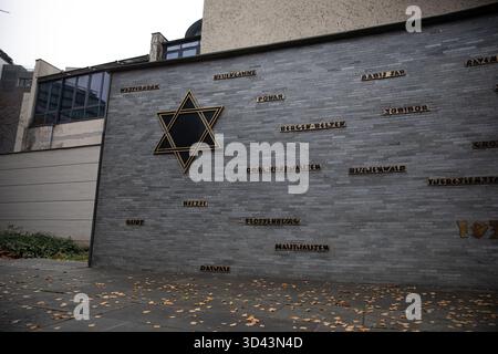 Berlin, Berlin, Deutschland. November 2025. An einem grauen Herbstsamstag, dem 8. November 2025, steht feierlich die Gedenkmauer im Jüdischen Gemeindezentrum in der Fasanenstraße, die die Namen der Konzentrations- und Vernichtungslager der Nazis trägt. Das Gelände markiert den Standort der ehemaligen Fasanenstraße-Synagoge, die während des Pogroms der Kristallnacht vom 9. November 1938 zerstört wurde. Während Deutschland sich morgen auf den 87. Jahrestag der Nacht des Glases vorbereitet, erinnert die Mauer stille an Verlust, Widerstandsfähigkeit und die Wiedergeburt der jüdischen Gemeinde in Berlin nach dem Holocaust. (Cre Stockfoto