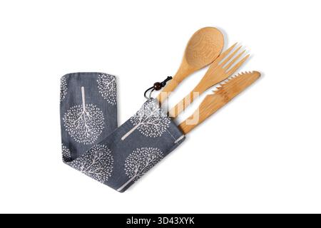 Wiederverwendbares, natürliches Bambusgabel-, Löffel- und gezacktes Messer-Set aus einer grauen Stofftasche mit weißem Baummuster, isoliert auf weiß Stockfoto