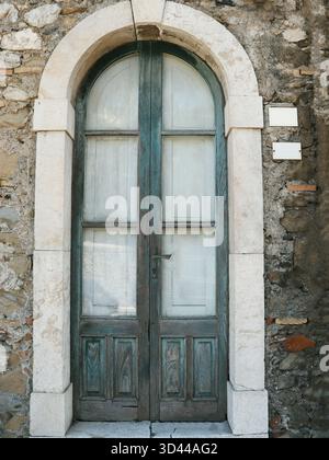 Alte braune Tür im Zentrum von Taormina, Italien. Strukturierte Tür. Vintage-Tür Stockfoto