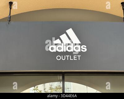 Belgrad, Serbien - 16. Juni 2024: Außenbeschilderung der Ladenfront von Adidas Outlet mit dem berühmten Logo und Branding in drei Streifen Stockfoto