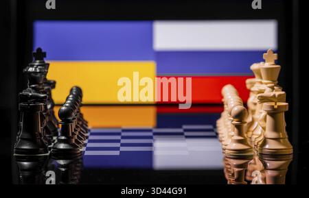 Konzeptuelles Bild des Krieges zwischen Russland und der Ukraine mit Schachfiguren und Nationalflaggen auf einem reflektierenden Hintergrund Stockfoto