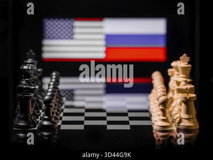 Konzeptuelles Bild des Krieges zwischen den Vereinigten Staaten und Russland mit Schachfiguren und Nationalflaggen auf einem reflektierenden Hintergrund Stockfoto
