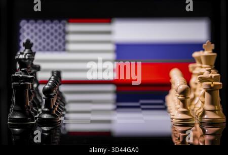 Konzeptuelles Bild des Krieges zwischen den Vereinigten Staaten und Russland mit Schachfiguren und Nationalflaggen auf einem reflektierenden Hintergrund Stockfoto