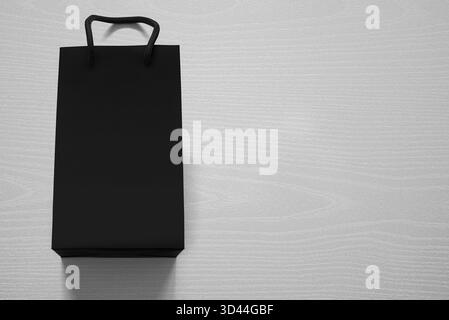 Luxuriöse, mattschwarze Einkaufstasche gegen weißes Holz von oben Stockfoto