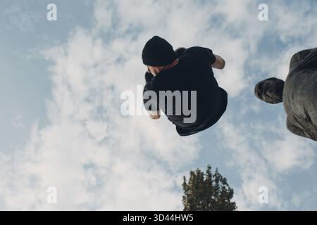 Junger sportlicher Kerl, der Parkour an der Stadtstraße macht Stockfoto