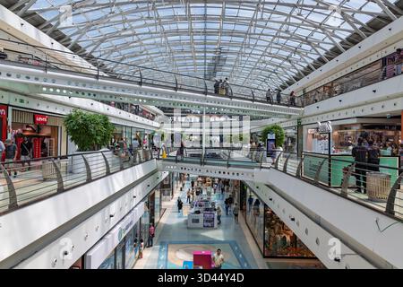 Lebendiges, mehrstöckiges Innere des Einkaufszentrums Centro Vasco da Gama in Lissabon, mit einem hellen Glasdach und geschäftiger Geschäftstätigkeit. Lissabon, Stockfoto