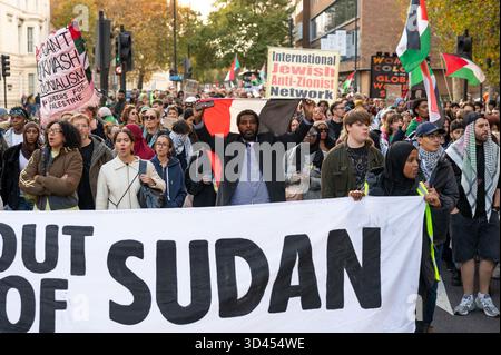 London, Großbritannien. November 2025. Demonstranten marschieren hinter einem Banner während der Kundgebung. Demonstranten marschierten in London, um Solidarität mit dem sudanesischen Volk zu zeigen und für ein Ende der britischen Waffenverkäufe an die VAE zu plädieren, die laut Aktivisten Gräueltaten der RSF-Miliz im ganzen Land ermöglichen. Quelle: SOPA Images Limited/Alamy Live News Stockfoto