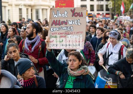 London, Großbritannien. November 2025. Eine Frau hält ein Plakat, während sie während der Kundgebung marschiert. Demonstranten marschierten in London, um Solidarität mit dem sudanesischen Volk zu zeigen und für ein Ende der britischen Waffenverkäufe an die VAE zu plädieren, die laut Aktivisten Gräueltaten der RSF-Miliz im ganzen Land ermöglichen. Quelle: SOPA Images Limited/Alamy Live News Stockfoto