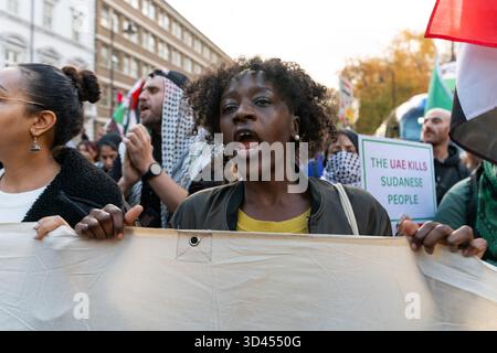 London, Großbritannien. November 2025. Eine Frau singt Slogans, während sie während der Kundgebung ein Banner hält. Demonstranten marschierten in London, um Solidarität mit dem sudanesischen Volk zu zeigen und für ein Ende der britischen Waffenverkäufe an die VAE zu plädieren, die laut Aktivisten Gräueltaten der RSF-Miliz im ganzen Land ermöglichen. Quelle: SOPA Images Limited/Alamy Live News Stockfoto