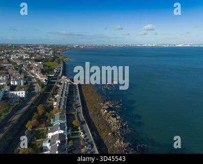 Drohnenaufnahme des historischen blackrock-Gebiets in dublin mit den Wohnhäusern, der Küste und der Bucht von dublin mit den Bergen in der Ferne Stockfoto