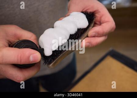 Close Hand Putzsauger, Kitchen Scene mit Händen und strukturiertem Schaumschwamm, ein intimes Foto, das Hände mit Seife bedeckt hält Stockfoto
