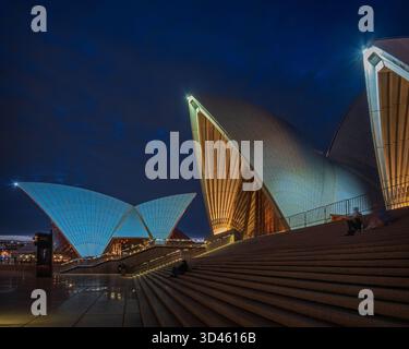Nächtlicher Blick über die Stufen des Sydney Opera House, Sydney, New South Wales, Australien, mit farbigen Lichtern. Stockfoto