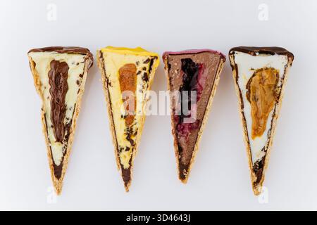 Verschiedene Eiskegel in Scheiben mit bunten Belägen und cremiger Füllung auf weißem Hintergrund Stockfoto