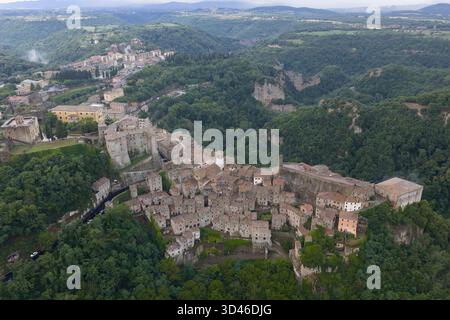 Blick aus der Vogelperspektive auf Sorano, Italien, mit mittelalterlicher Architektur, eingebettet in üppige toskanische Hügel. Steinbauten und befestigte Mauern dominieren diesen Historismus Stockfoto