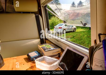 Blick aus einem Wohnmobilfenster, wo auf einer Wiese ein Polizeifahrzeug steht. Siebenbürgen Transilvanien Karpaten Rumänien ein Polizeifahrzeug durch ein Fenster eines Wohnmobils *** Blick von einem Wohnmobil-Fenster, wo ein Polizeiauto auf einer Wiese parkt Transsilvanien Karpaten Rumänien Ein Polizeifahrzeug durch ein Fenster eines Wohnmobils Stockfoto