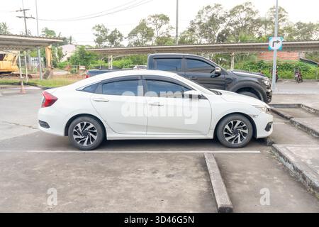 Weiße Sportlimousine mit Blick von der rechten Seite parkt auf dem offenen Parkplatz des Kaufhauses. Stockfoto