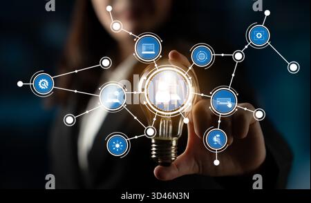 Eine Geschäftsfrau interagiert mit einer innovativen digitalen Schnittstelle mit einer Glühlampe, die Kreativität und Technologie am modernen Arbeitsplatz symbolisiert Stockfoto