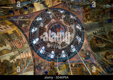 Kunstvolle orthodoxe Fresken und goldener Kronleuchter unter der bemalten Kuppel der Hauptkirche des Bachkowo-Klosters in Bulgarien. Stockfoto
