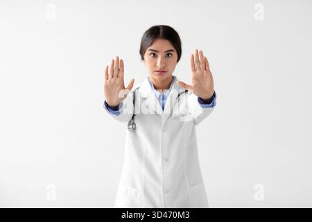 Young Indian Lady Doctor macht Stop Sign, um die Sicherheit während der Pandemie zu fördern Stockfoto