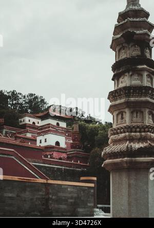 Erleben Sie die komplizierten Details einer alten Steinpagode und traditionellen gestuften Strukturen auf einem historischen Hügel in Peking, China. Stockfoto