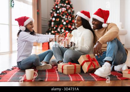 Happy Black Family feiert Weihnachtsgeschenke im gemütlichen Wohnzimmer Stockfoto
