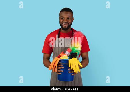 Frühjahrsputz. Portrait Von Smiling Black Cleaner Guy Holding Korb Von Waschmitteln Stockfoto