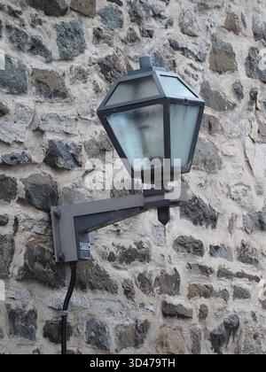 Historische Straßenlaterne an der Wand in einem Steingebäude in Old Quebec City, Kanada. Stockfoto