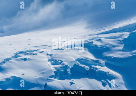 Eine beschauliche antarktische Landschaft in der Nähe des Hafens Mikkelsen auf Trinity Island, mit starken Reflexen, zerklüfteten Bergen und beeindruckenden Eisbergen Stockfoto