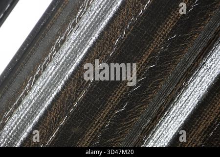 Abstrakter Makrohintergrund mit metallischer Textur. Das silberne und schwarze Industriemuster mit diagonalem Streifendesign schafft moderne und futuristische Elemente Stockfoto