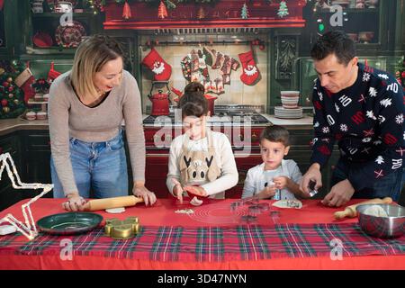 Glückliche Familie, die zusammen weihnachtskekse backen, Feiertage-Traditionen machen und die Weihnachtszeit genießen kann Stockfoto