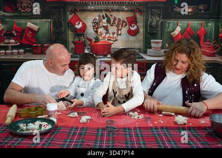 Glückliche Familie, die weihnachtskekse in einer dekorierten Küche für die Weihnachtsfeier kreiert Stockfoto