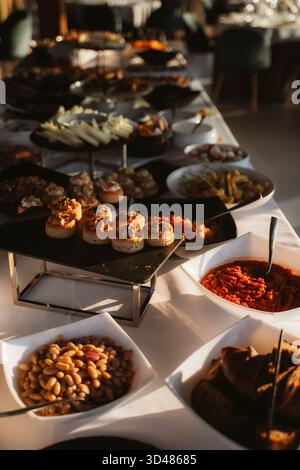 Der elegante Buffettisch bietet eine Vielzahl von Vorspeisen, darunter Canape, Dips und Fingerfood, die attraktiv angeordnet sind. Perfekt für Veranstaltungen und Versammlungen Stockfoto