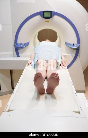 Unerkennbare reife Frau, die bei einer Ganzkörperuntersuchung in der modernen Klinik eine MRT-Untersuchung durchläuft Stockfoto