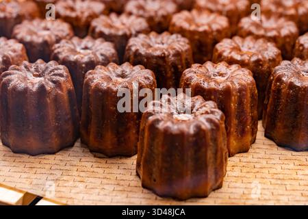 Kuala Lumpur, Malaysia - 6. November 2025 : Französische Kanelen (Canele de Bordeaux) ordentlich auf einem Tablett angeordnet. Stockfoto