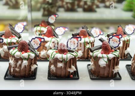 Kuala Lumpur, Malaysia - 6. November 2025 : dekorierter Schokoladen-Chiffon mit Erdbeeren, Fudge-Schokolade und Weihnachtsmann-Topper für die Weihnachtsausstellung. Stockfoto