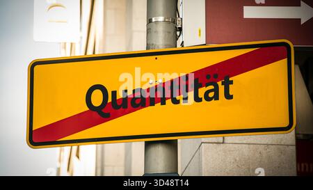Ein Bild mit einem Wegweiser, der in zwei verschiedene Richtungen auf Deutsch zeigt. Eine Richtung ist Qualität, die andere ist Quantität. Stockfoto