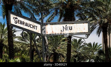 Ein Bild mit einem Wegweiser, der in zwei verschiedene Richtungen auf Deutsch zeigt. Eine Richtung ist neu, die andere wird verwendet. Stockfoto