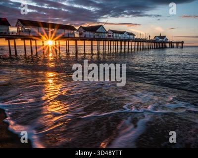 Am frühen Morgen scheint Sonnenlicht durch die Stützen des Southwold Pier Stockfoto