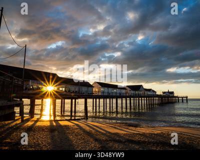 Am frühen Morgen scheint Sonnenlicht durch die Stützen des Southwold Pier Stockfoto